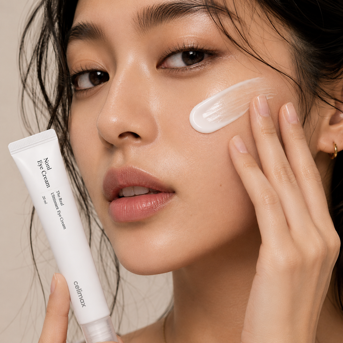 Woman applying Celimax Noni Eye Cream to the under-eye area