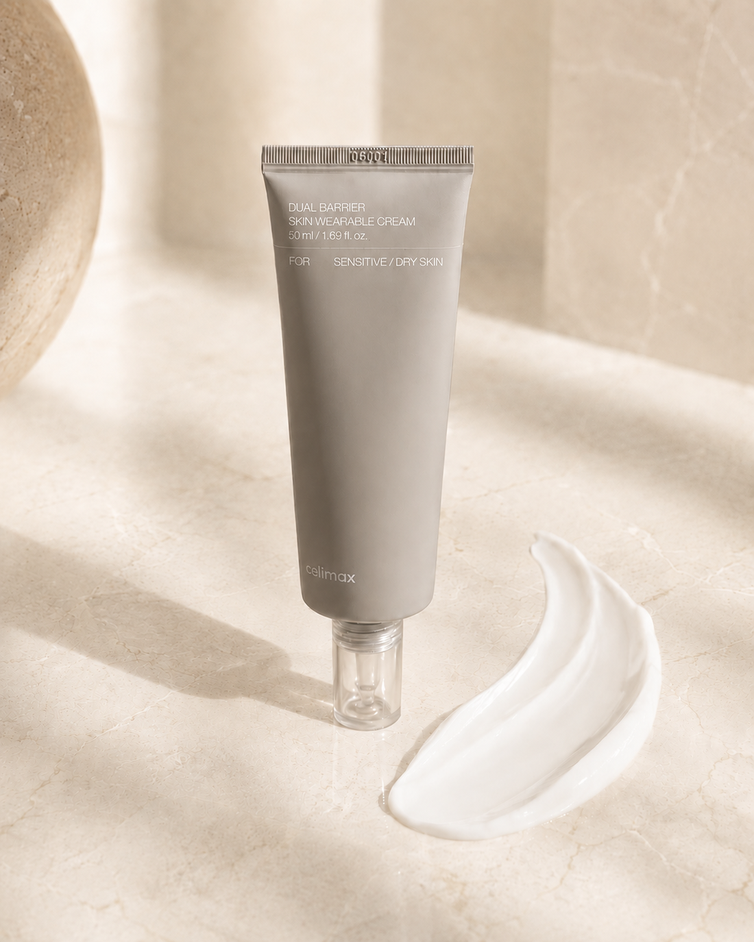 Celimax Dual Barrier Cream tube on marble with a soft ribbon of cream, editorial still life