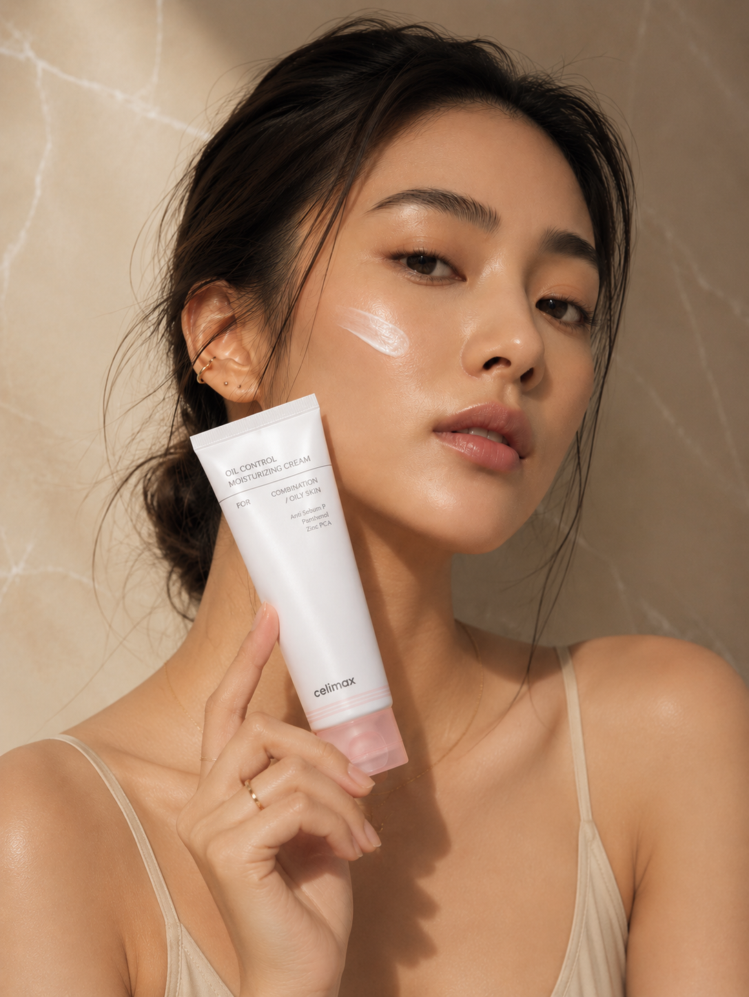 Woman holding Celimax Oil Control Moisturizing Cream tube during her skincare routine