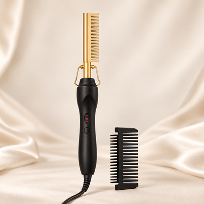 Gold electric hot comb aligned upright with a black handle and separate guard on a warm beige background