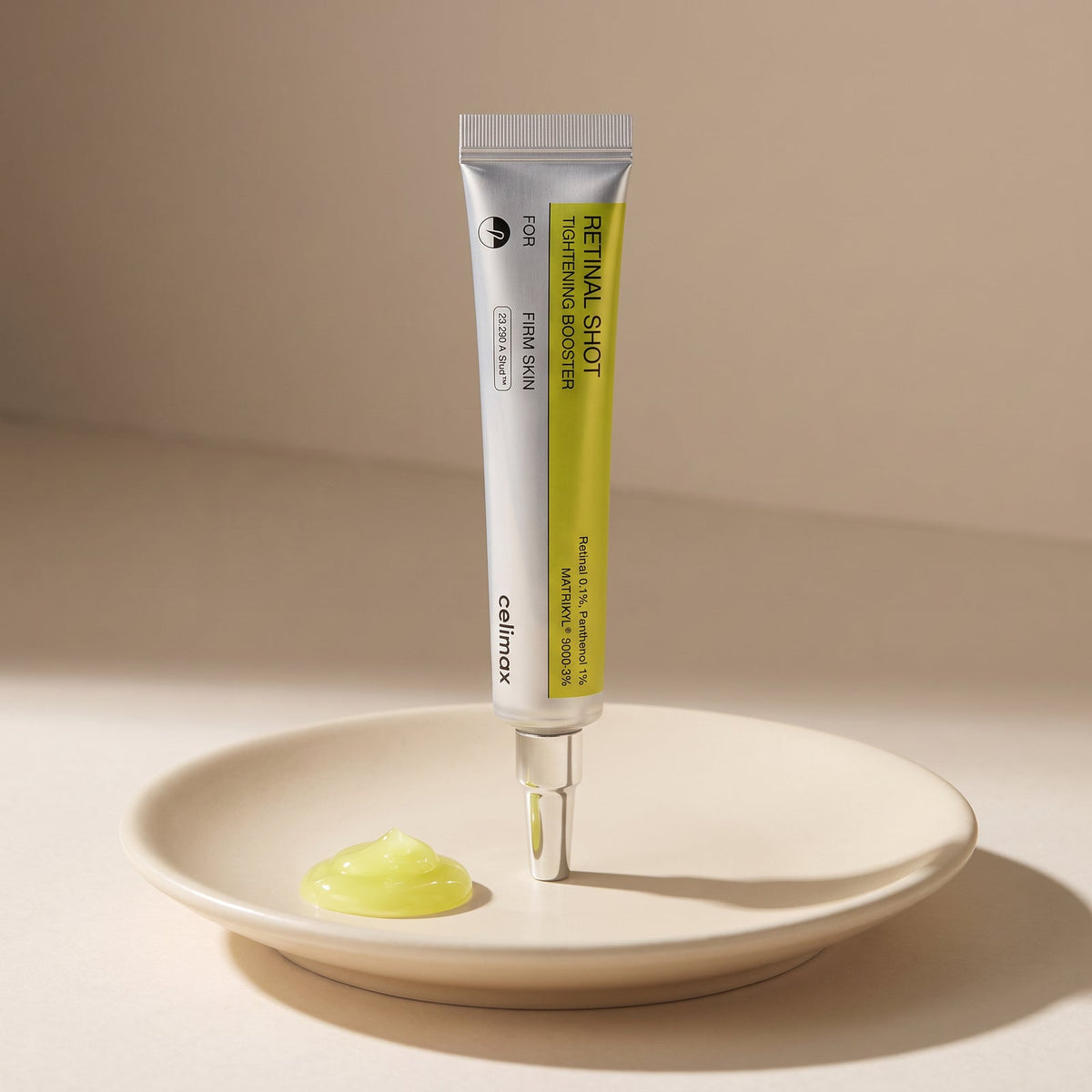Celimax Retinal Shot Tightening Booster tube standing beside a dollop of gel on a ceramic dish