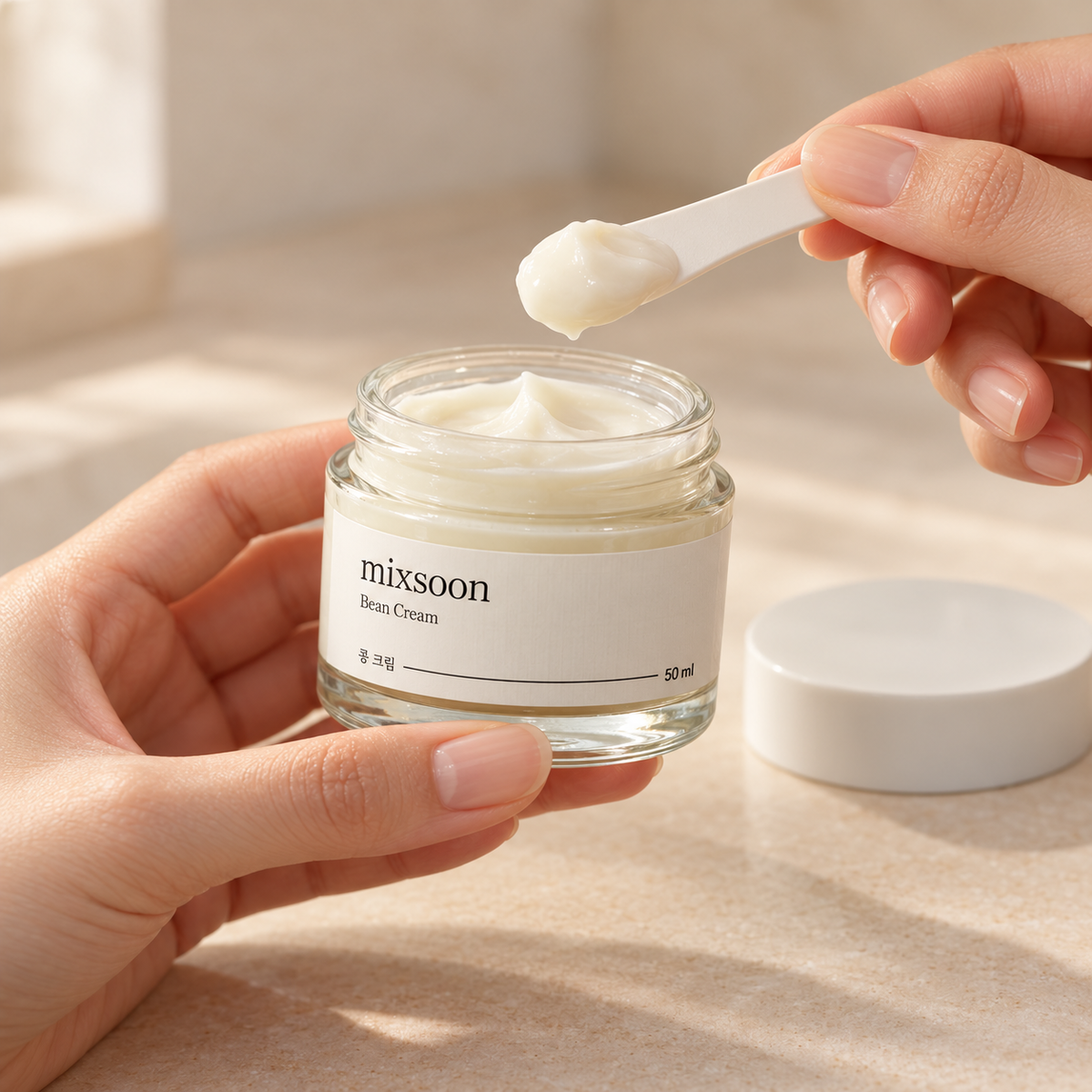 Illustration of taking a small amount of Mixsoon Bean Cream with a clean cosmetic spatula