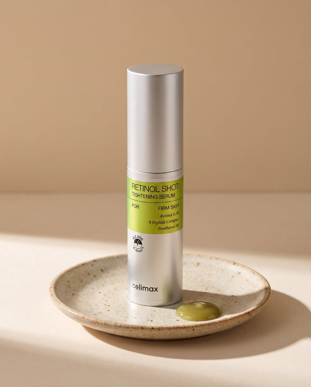 Celimax Retinol Shot Tightening Serum bottle on a ceramic dish with a drop of serum