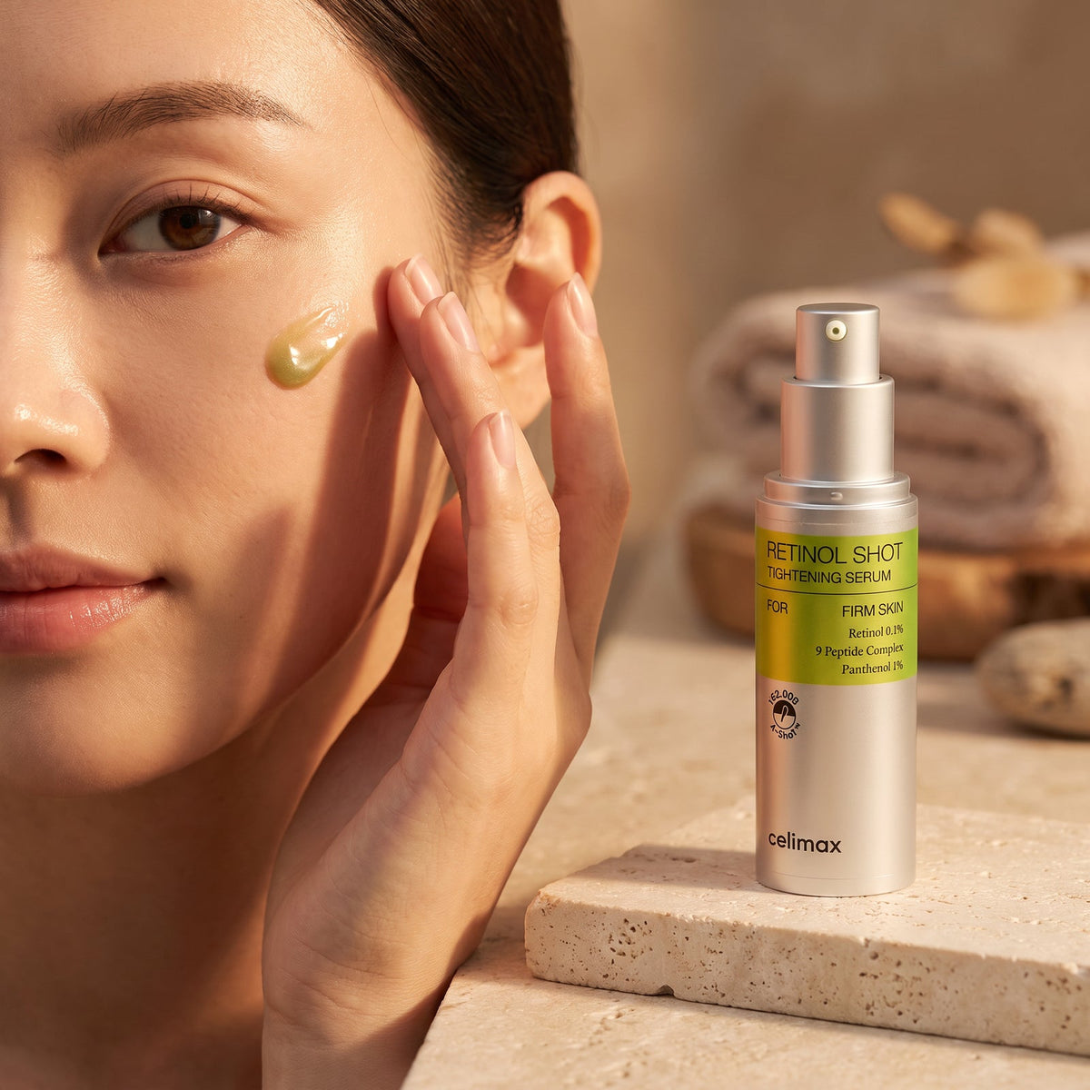 Woman applying Celimax Retinol Shot Tightening Serum to her cheek in soft evening light